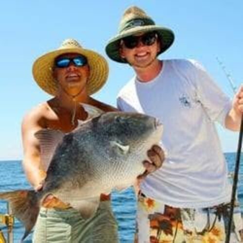 A couple holding a large triggerfish caught offshore
